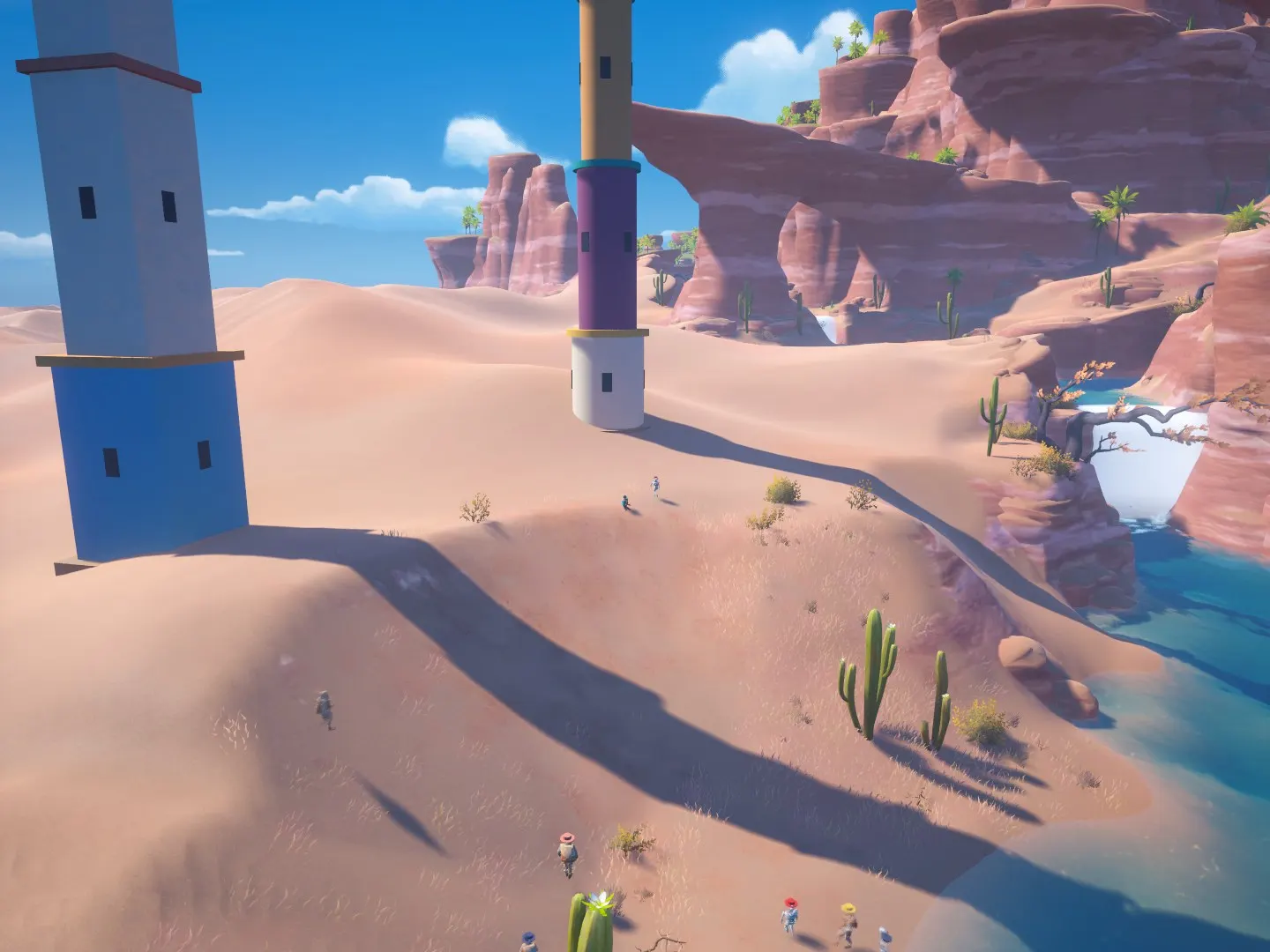 Tall painted towers rising from desert dunes under a blue sky